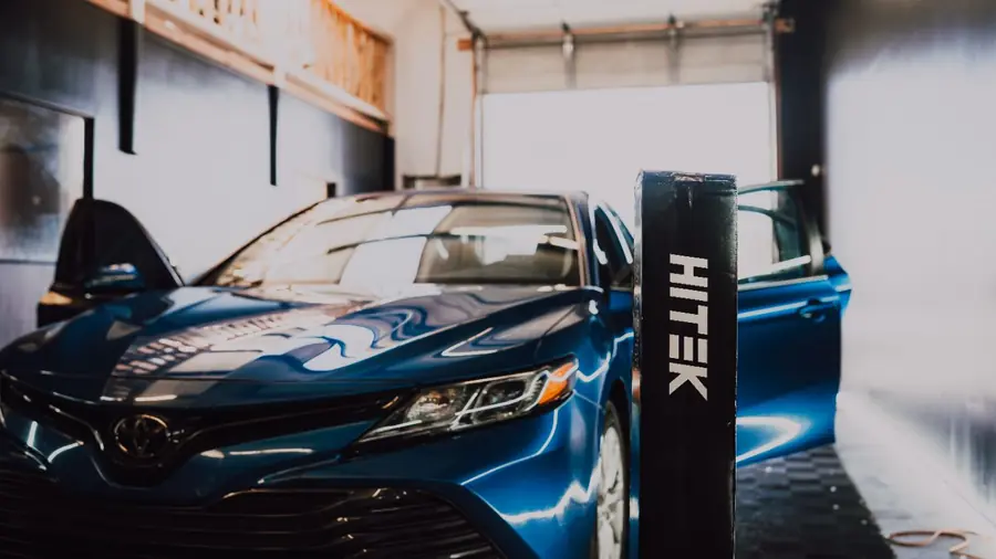 Blue Toyota Camry with freshly installed window tint in the Evo Solutions bay